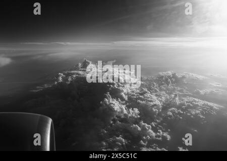 Vista dalla finestra di un aereo che vola sopra le nuvole, foto in bianco e nero. Foto Stock