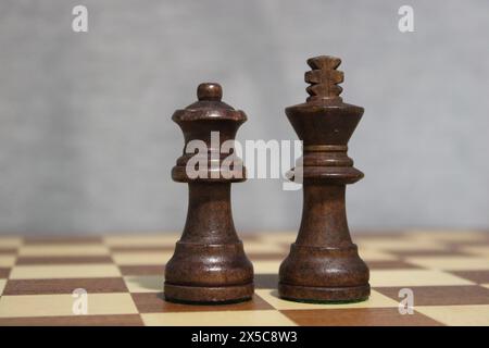 Il re e la regina neri in piedi su una scacchiera Foto Stock