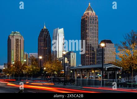 Luci di posizione posteriori a strisce di traffico serale sotto lo skyline di Midtown Atlanta dalla Atlantic Station di Atlanta, Georgia. (USA) Foto Stock