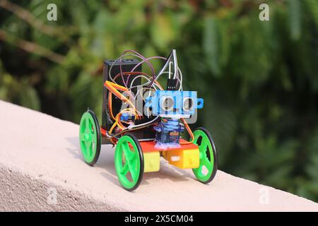 Piccola auto robotica realizzata utilizzando semplici componenti elettronici come motore c.c. e sensore a ultrasuoni controllati da un microcontrollore Foto Stock