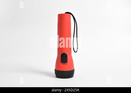 Torcia di colore rosso isolata su sfondo bianco. Torcia rossa alimentata a batteria Foto Stock