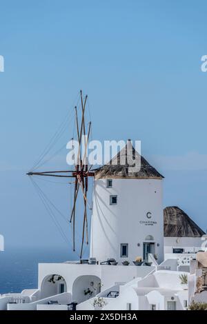 Santorini, Grecia, 4 maggio 2024. Oia, Vista del villaggio con il mulino a vento Foto Stock