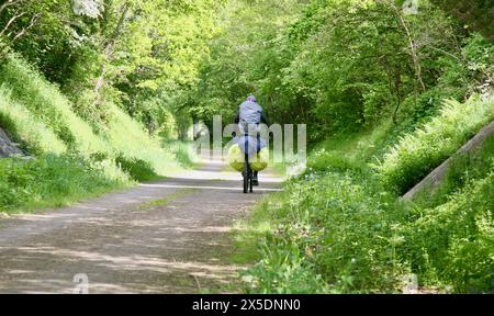 Un ciclista che si dirige a est, lungo la Parigi Veloscenica fino alla ciclabile le Mont Saint Michel, Barenton, Normandia, Francia, Europa nella primavera del 2024. Foto Stock