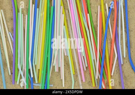 Cannucce di plastica colorate, rifiuti in spiaggia dopo un festival estivo o una festa. Vista dall'alto. Foto Stock
