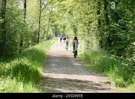 Ciclisti sulla pista ciclabile Veloscenica da Parigi a Mont-Saint-Michel a Barenton, Normandia, Francia nordoccidentale, Europa nella primavera del 2024 Foto Stock