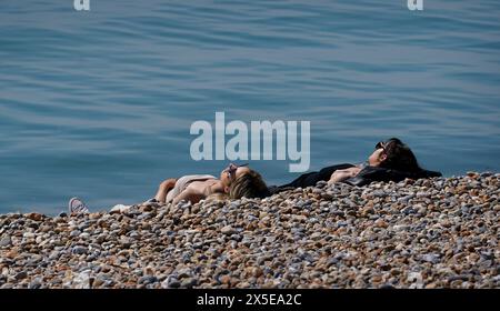 La gente ama il clima caldo sulla spiaggia di Hastings, nell'East Sussex. Data foto: Giovedì 9 maggio 2024. Foto Stock