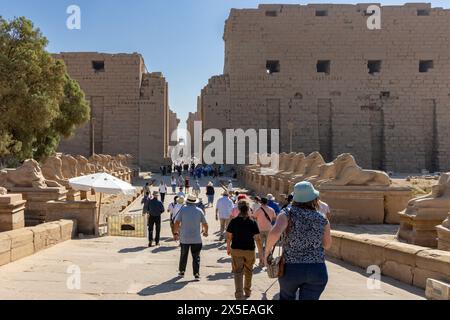 Turisti che arrivano all'antico complesso egizio del tempio di Karnak. Situato a Luxor, alto Egitto, oggi patrimonio dell'umanità dell'UNESCO. Foto Stock