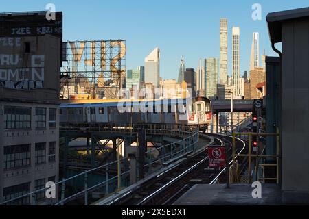 New York City, treno numero 7 e binari della metropolitana sopraelevati a Long Island City con vista mattutina dei grattacieli dell'Upper East Side (Manhattan) Foto Stock