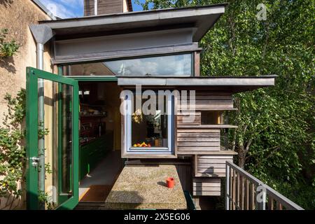 Livelli di legno a strati rendono interessante l'esterno della veranda al primo piano. Straw Bale House, Islington, Regno Unito. Architetto: Sarah Wiggles Foto Stock