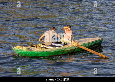 Gli egiziani locali pescano sul fiume Nilo in Egitto. Vengono utilizzate piccole imbarcazioni a remi da cui vengono gettate le reti e poi rimesse a punto. Foto Stock