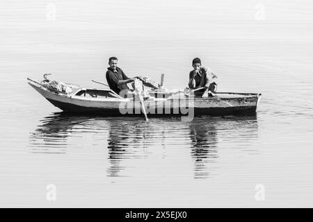 Gli egiziani locali pescano sul fiume Nilo in Egitto. Vengono utilizzate piccole imbarcazioni a remi da cui vengono gettate le reti e poi rimesse a punto. Foto Stock