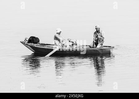 Gli egiziani locali pescano sul fiume Nilo in Egitto. Vengono utilizzate piccole imbarcazioni a remi da cui vengono gettate le reti e poi rimesse a punto. Foto Stock