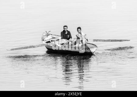 Gli egiziani locali pescano sul fiume Nilo in Egitto. Vengono utilizzate piccole imbarcazioni a remi da cui vengono gettate le reti e poi rimesse a punto. Foto Stock