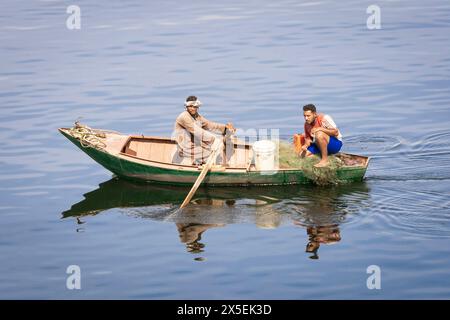 Gli egiziani locali pescano sul fiume Nilo in Egitto. Vengono utilizzate piccole imbarcazioni a remi da cui vengono gettate le reti e poi rimesse a punto. Foto Stock