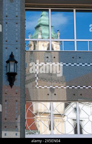 La torre dell'orologio dello storico Municipio di Bratislava si riflette sulla facciata di un edificio sulla piazza principale della città. Foto Stock