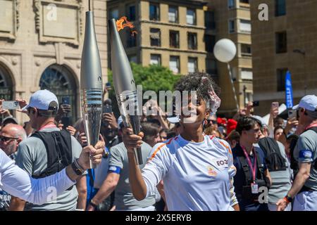 Marsiglia, Francia. 9 maggio 2024. Il portatore di Tourch Maryam Kaba passa la torcia olimpica durante la staffetta della fiamma olimpica di Parigi 2024 a Marsiglia, Francia, 9 maggio 2024. Crediti: Julien Mattia/Xinhua/Alamy Live News Foto Stock