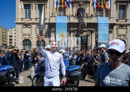 Marsiglia, Francia. 9 maggio 2024. Matthieu Gudet, vigile del fuoco locale e portatore di torcia, detiene la torcia olimpica durante la staffetta della fiamma olimpica di Parigi 2024 a Marsiglia, Francia, 9 maggio 2024. Crediti: Julien Mattia/Xinhua/Alamy Live News Foto Stock