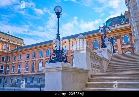 La scalinata in pietra bianca per le porte asburgiche del Castello di Buda, decorata con dettagli scolpiti e luci d'epoca in ghisa, Budapest, Ungheria Foto Stock