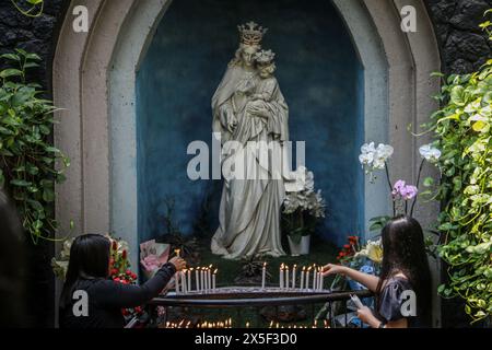 Bandung, Indonesia. 9 maggio 2024. I cristiani accendono candele di fronte alla statua della Vergine Maria nella chiesa della cattedrale di San Pietro, Jalan Merdeka, Bandung City il 9 maggio 2024. La chiesa cattedrale di San Pietro ha tenuto quattro sessioni di culto per la messa dell'Ascensione di Gesù Cristo. (Foto di Rasyad Yahdiyan/INA Photo Agency) credito: SIPA USA/Alamy Live News Foto Stock