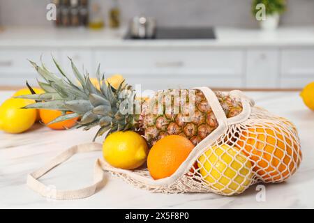 Sacchetto con spago con frutta fresca su un tavolo leggero in cucina Foto Stock