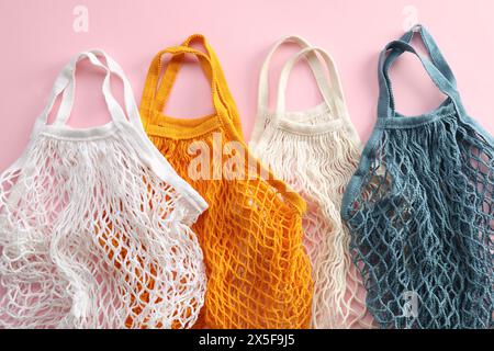 Sacchetti con cordoncino diversi su sfondo rosa, vista dall'alto Foto Stock