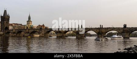 Praga, repubblica ceca - 3 marzo 2024: Panorama dei turisti che camminano sul ponte Carlo visto sotto dal fiume Moldava. Foto Stock