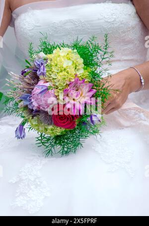 Primo piano di una sposa con un piccolo mazzo di fiori Foto Stock