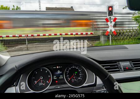 Auto in attesa a un passaggio a livello, barriere chiuse, semaforo rosso, semaforo e St. Andrew's Cross, RRX, Rhein-Ruhr-Express, National Express p Foto Stock