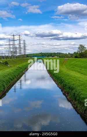 L'Emscher vicino a Essen-Karnap, con il cumulo di scorie di Schurenbach sullo sfondo, con il punto di riferimento di Bramme per la regione della Ruhr, Emscher Island Foot e. Foto Stock