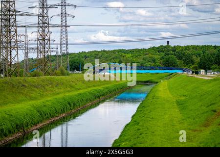 L'Emscher vicino a Essen-Karnap, con il cumulo di scorie di Schurenbach sullo sfondo, con il punto di riferimento di Bramme per la regione della Ruhr, Emscher Island Foot e. Foto Stock