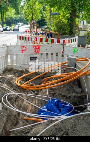 Posa di cavi in fibra ottica, i condotti vuoti sono posti sotto un marciapiede, in cui il cavo in fibra ottica effettivo viene successivamente soffiato e collegato alla r Foto Stock