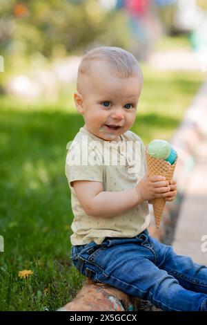 il bambino mangia il gelato nel parco in estate. Foto di alta qualità Foto Stock