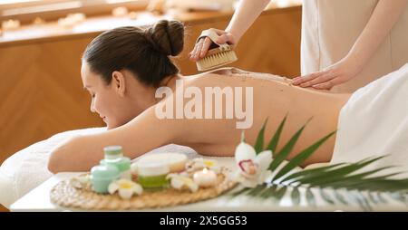 Giovane donna ricevere massaggio scrub in spa salone Foto Stock