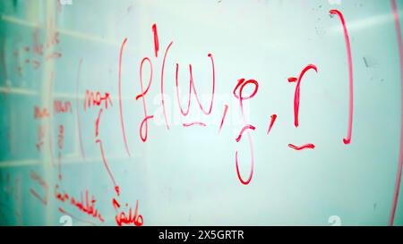 Formula matematica e note scritte in rosso su una lavagna bianca, raffiguranti la complessità e la natura dinamica della ricerca accademica e della scienza Foto Stock