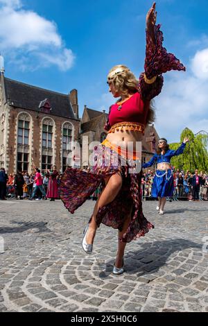 Una donna vestita da personaggio della Bibbia balla durante la festa cattolica della Processione del Sacro sangue il giorno dell'Ascensione. Celebrando la giornata dell'Ascensione a Bruges, in Belgio, la città si anima con l'annuale festa cattolica che presenta la famosa Processione del Sacro sangue. I partecipanti indossano elaborati costumi religiosi e storici, che si aggiungono alla solennità e alla grandezza dell'evento. Le strade si trasformano in vivaci spettacoli di fede e tradizione mentre la processione si snoda attraverso la città, attirando folle di fedeli devoti e curiosi curiosi, catturando la città Foto Stock