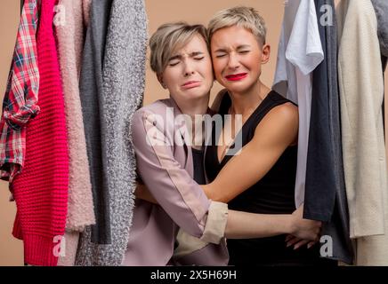 le belle e tristi giovani donne piangono mentre fanno shopping. Premi emotivi, vendite.infelici abbracciare ragazze hanno perso il Black Friday Foto Stock