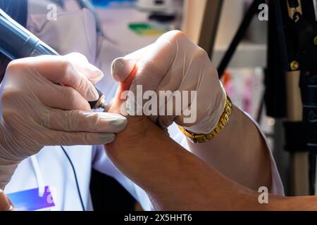 Un cosmetologo professionista fa una pedicure hardware sulla gamba di una donna nella cabina. Primo piano sul tallone delle gambe e la procedura di hardware Pedic Foto Stock