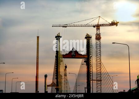 Negli ultimi anni, le gru a torre sono emerse come uno strumento prezioso per la costruzione di ponti nei cantieri edili. Con la loro capacità di sollevare e spostare carichi pesanti Foto Stock