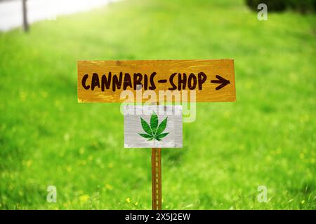 FOTOMONTAGE, Schild mit Hanfblatt und Aufschrift Cannabis Shop Foto Stock