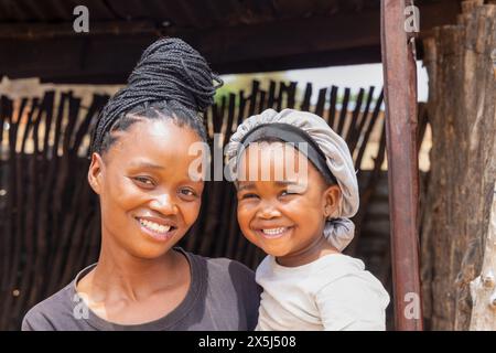 villaggio africano madre e bambino in piedi all'ingresso della baracca, villaggio di città in sud africa Foto Stock