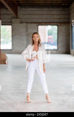 Donna sicura di sé in abito bianco in magazzino Foto Stock