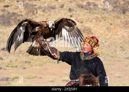 Asia, Mongolia, provincia di Bayan-Olgii. Altai Eagle Festival, ritratto di un giovane cacciatore di aquile kazako con la sua aquila d'oro. (Solo per uso editoriale) Foto Stock