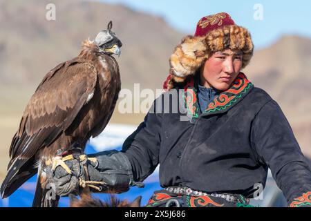 Asia, Mongolia, provincia di Bayan-Oglii. Altai Eagle Festival, giovane kazako posa con la sua aquila. (Solo per uso editoriale) Foto Stock