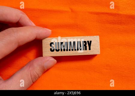 Parola sintetica scritta su un blocco di legno con sfondo arancione. Simbolo della parola di riepilogo concettuale. Copia spazio. Foto Stock