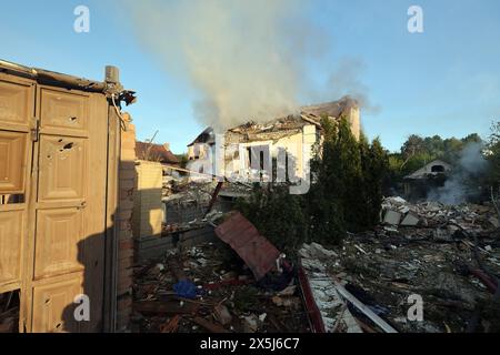 CHARKIV, UCRAINA - 10 MAGGIO 2024 - il fumo sorge su una casa dopo un attacco missilistico russo, Charkiv, Ucraina nord-orientale. La notte del 10 maggio, gli invasori russi attaccarono Charkiv con un missile S-300. Un bambino di 11 anni e una donna di 72 anni sono rimasti feriti a causa dell'attacco al settore privato. Tre case erano in fiamme, due di loro sono state distrutte e una è stata danneggiata. In totale, 26 edifici sono stati distrutti e più di 300 finestre sono state distrutte. Foto Stock