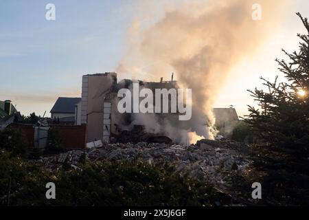 CHARKIV, UCRAINA - 10 MAGGIO 2024 - il fumo sorge su una casa dopo un attacco missilistico russo, Charkiv, Ucraina nord-orientale. La notte del 10 maggio, gli invasori russi attaccarono Charkiv con un missile S-300. Un bambino di 11 anni e una donna di 72 anni sono rimasti feriti a causa dell'attacco al settore privato. Tre case erano in fiamme, due di loro sono state distrutte e una è stata danneggiata. In totale, 26 edifici sono stati distrutti e più di 300 finestre sono state distrutte. Foto Stock