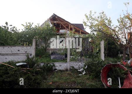 CHARKIV, UCRAINA - 10 MAGGIO 2024 - Una casa è danneggiata da un attacco missilistico russo, Charkiv, Ucraina nord-orientale. La notte del 10 maggio, gli invasori russi attaccarono Charkiv con un missile S-300. Un bambino di 11 anni e una donna di 72 anni sono rimasti feriti a causa dell'attacco al settore privato. Tre case erano in fiamme, due di loro sono state distrutte e una è stata danneggiata. In totale, 26 edifici sono stati distrutti e più di 300 finestre sono state distrutte. Foto Stock