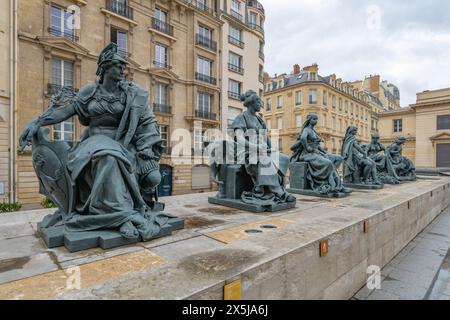 Una fila di statue allegoriche che rappresentano i continenti sulla terrazza del Museo d'Orsay, con i visitatori sullo sfondo. Foto Stock