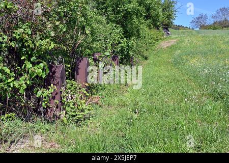 Binari in metallo utilizzati come ostacoli anticarro e protezione militare fortificata posti in fila che sono stati costruiti durante la seconda guerra mondiale in Svizzera. Foto Stock