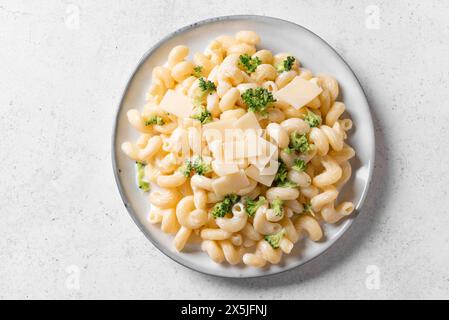 Pasta Cavatappi Alfredo fatta in casa con broccoli su piatto bianco, vista dall'alto. Pasta vegana cremosa con broccoli e parmigiano. Foto Stock